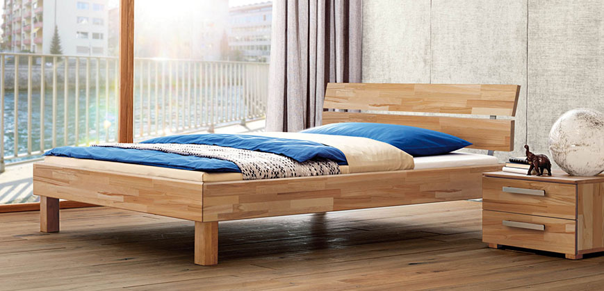 ugendbett aus Holz mit Nachttisch vor Fensterfront 